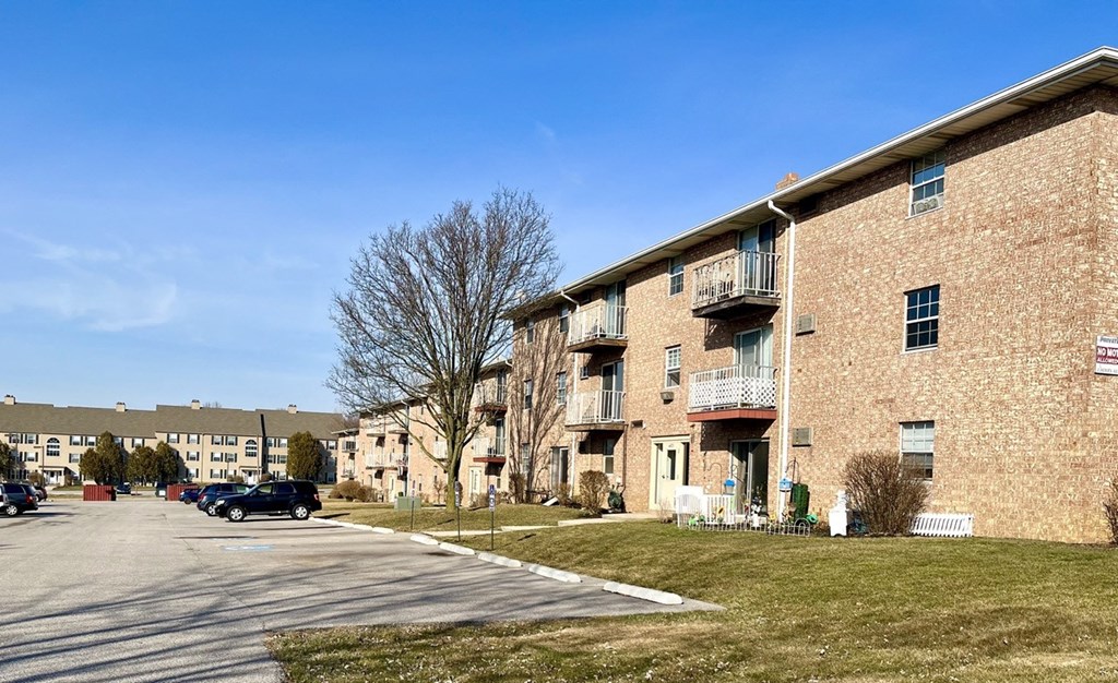 a row of brick apartment buildings on the side of a street
