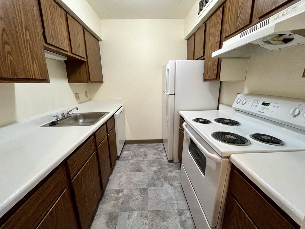 a kitchen with white appliances and wooden cabinets