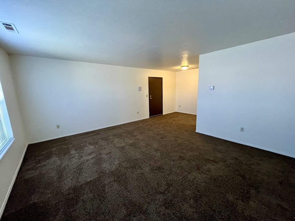 living room with carpet and white walls and a dining area