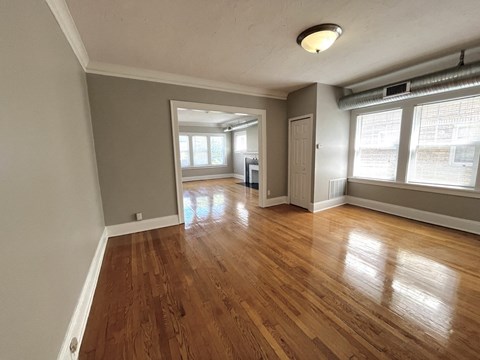 an empty living room with wood floors and windows