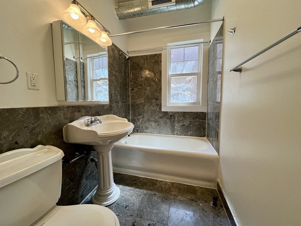 a bathroom with a sink toilet and a bath tub