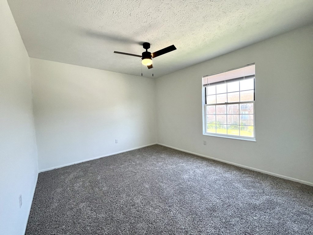 an empty bedroom room with a ceiling fan and a window at Renova of Brunswick, Ohio 