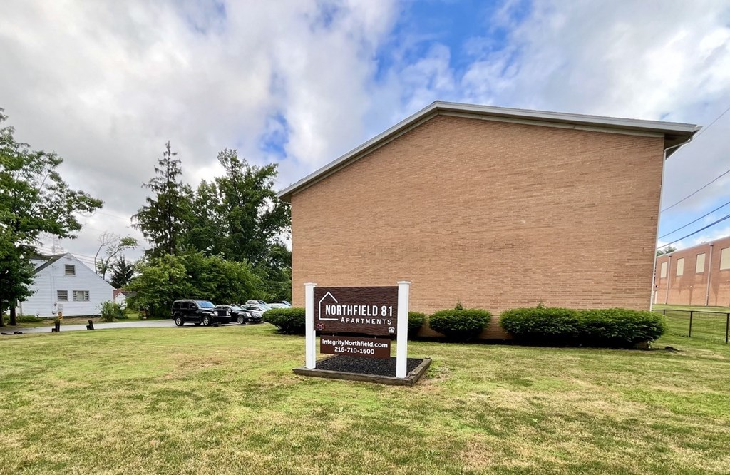 a brick building with a sign in front of it