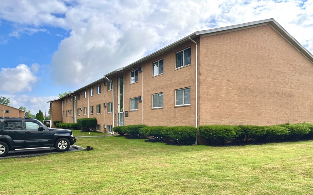 a brick apartment building with a truck parked outside