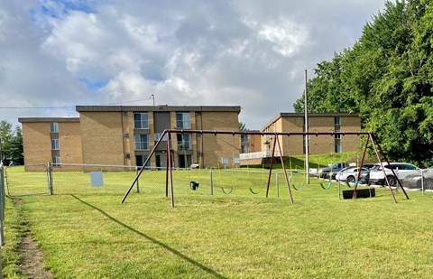 a swing set in front of an apartment building