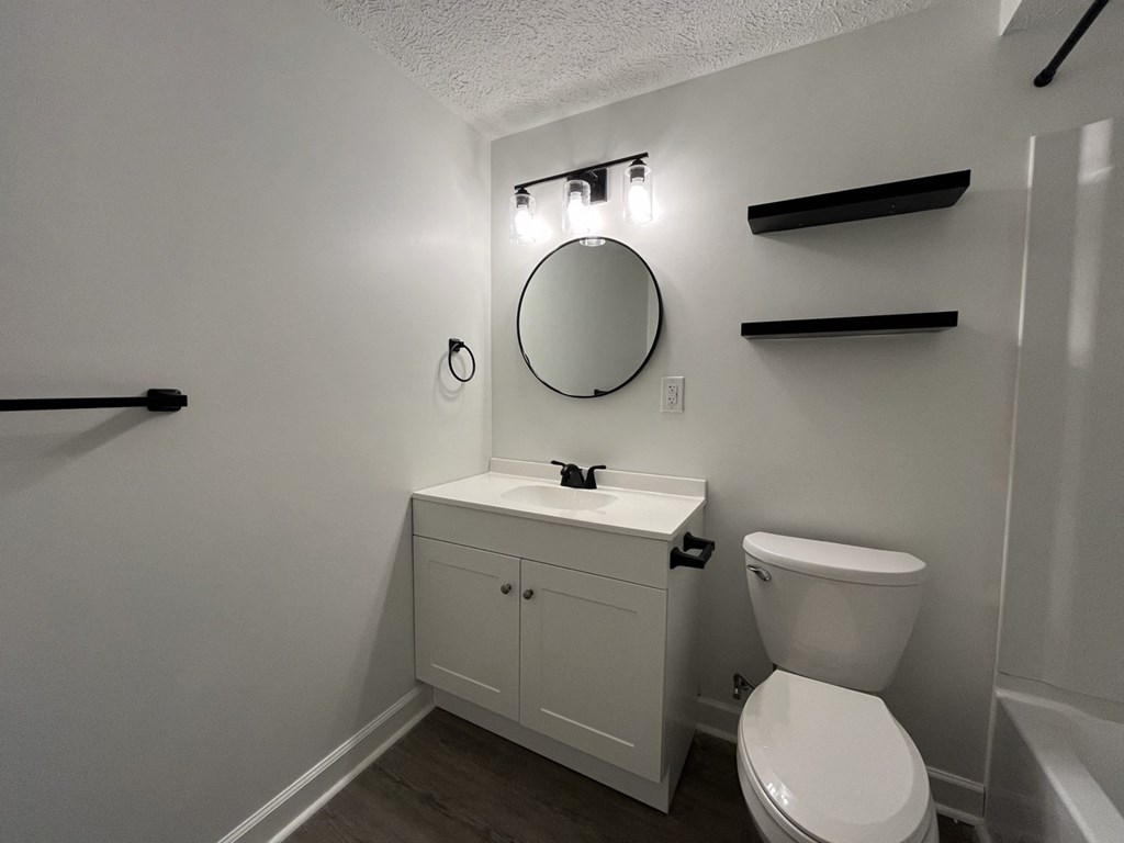 a renovated bathroom with a toilet and a sink and a mirror