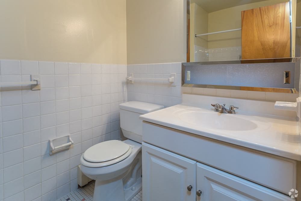 a white bathroom with a toilet and a sink