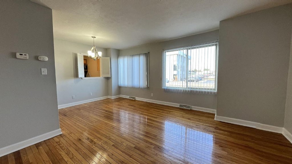 an empty living room with a hardwood floor