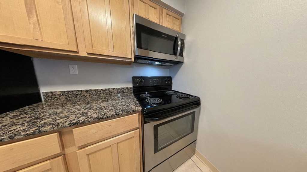 a kitchen with a stove top oven and a microwave