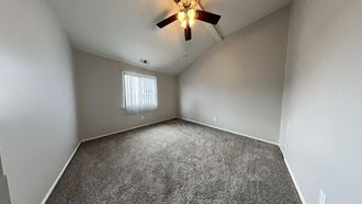 an empty room with a ceiling fan and a window - Photo Gallery