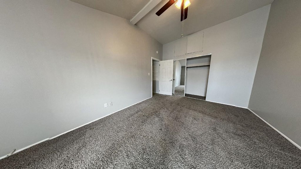 an empty living room with a ceiling fan