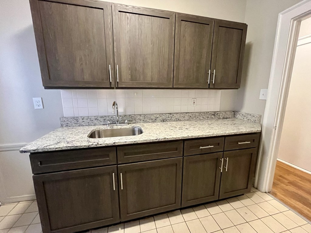 an empty kitchen with wooden cabinets and a sink