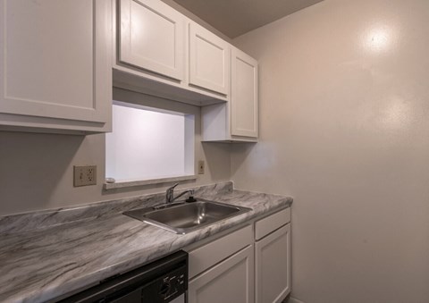 the kitchen of a home with white cabinets and a sink