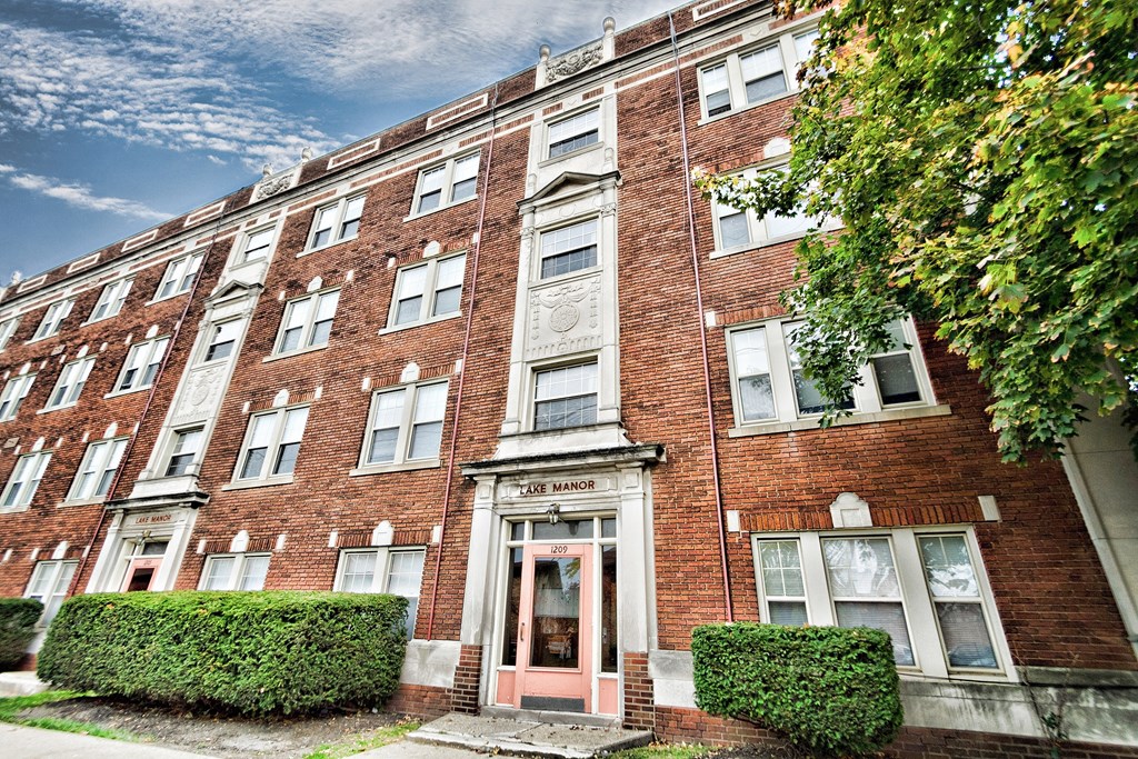 a red brick apartment building with pink doors and windows