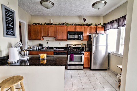 the kitchen has granite counter tops and stainless steel appliances