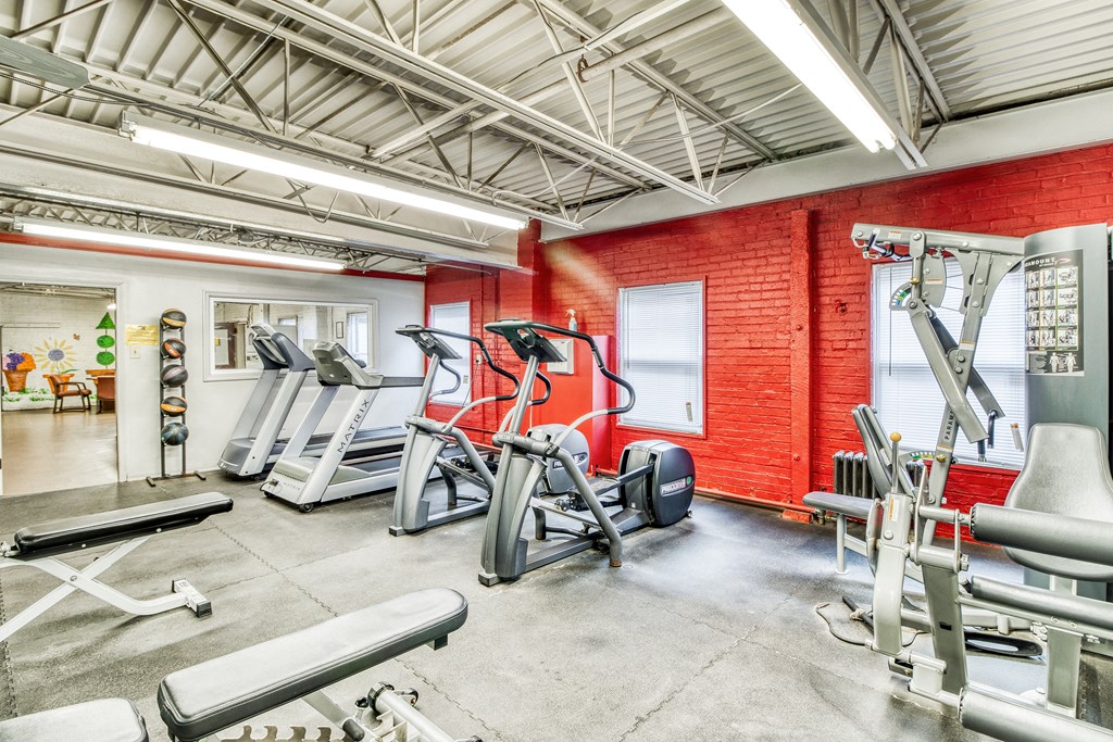 a gym with cardio equipment and weights in a loft