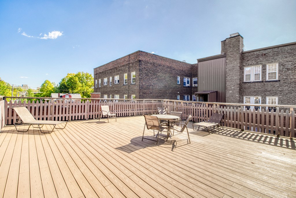 a deck with a table and chairs and a brick building