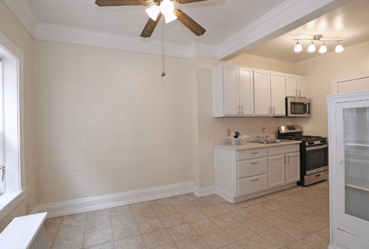 a kitchen with a ceiling fan and a stove and a sink
