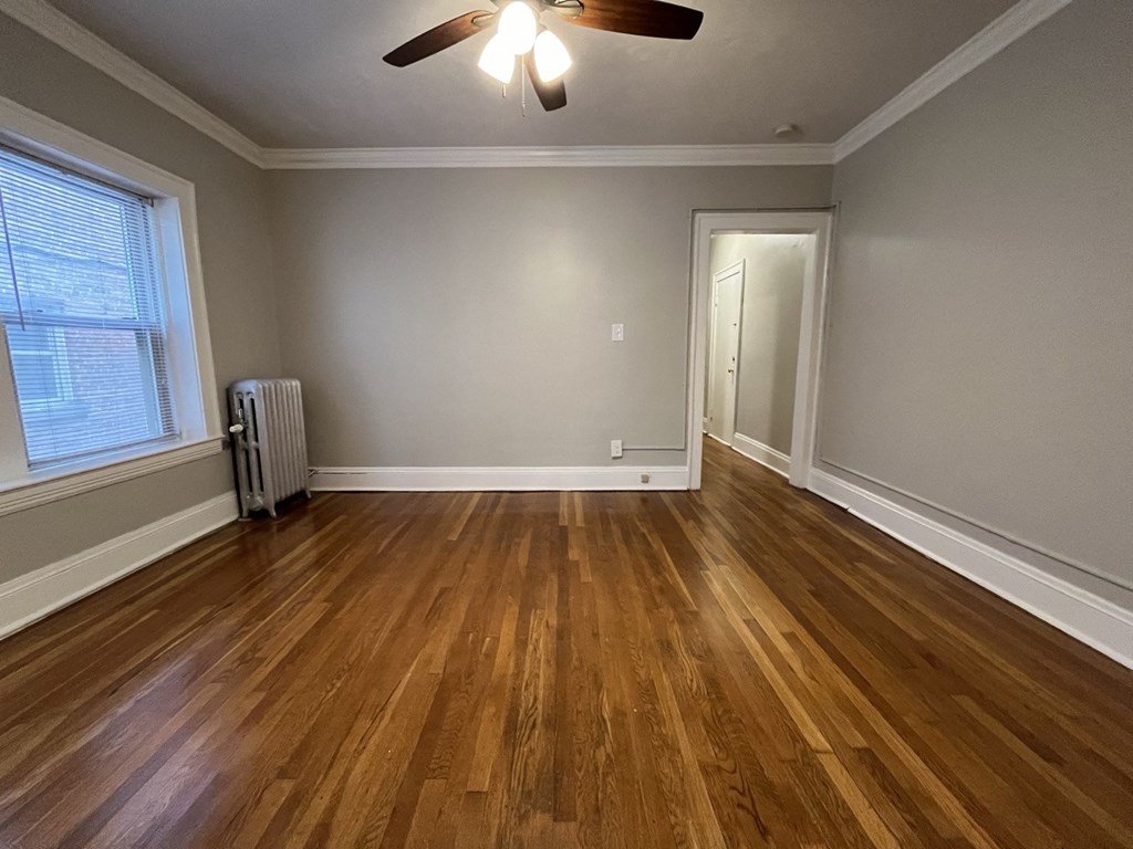 an empty dining room with wooden floors and a ceiling fan
