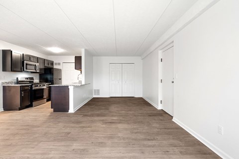 A kitchen with dark brown cabinets and white walls.