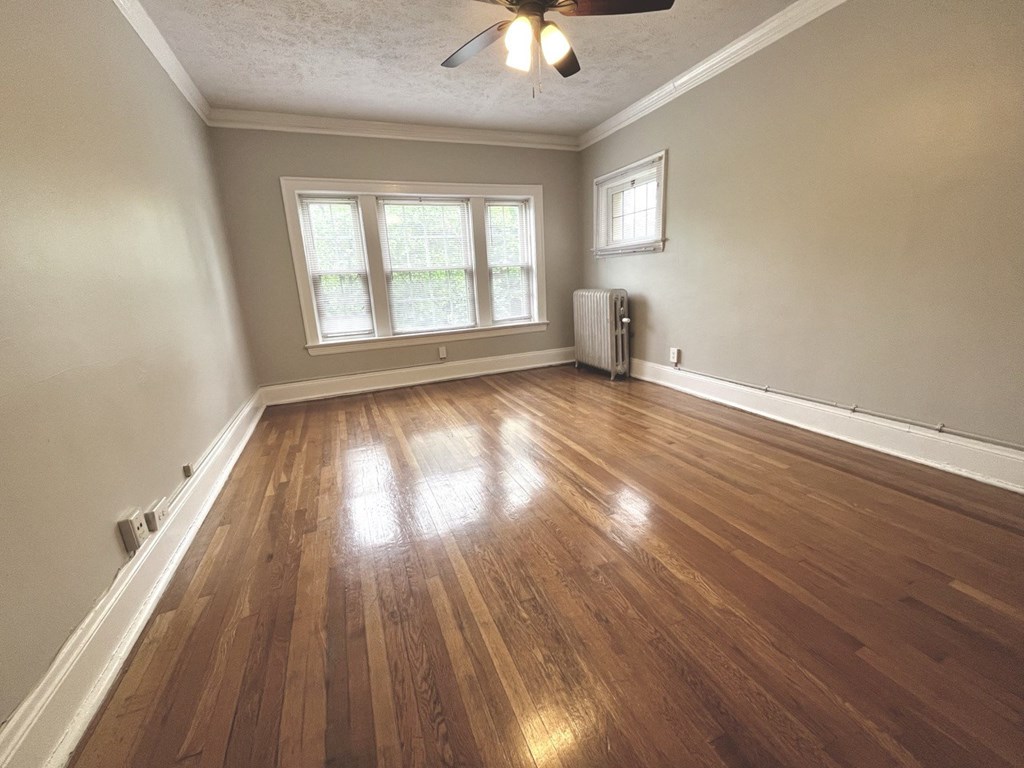 an empty living room with wooden floors and a window