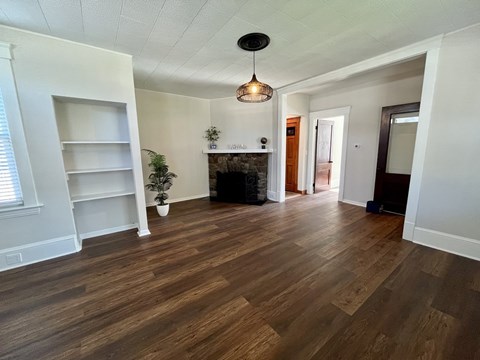 A room with wooden floors and a fireplace.