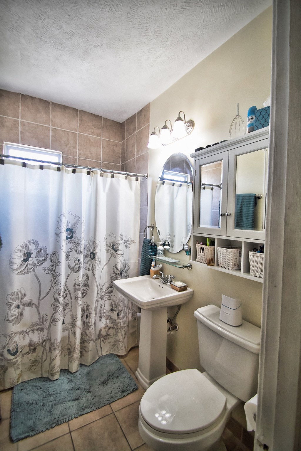 a small bathroom with a shower curtain and a toilet and sink