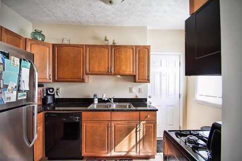 a kitchen with wooden cabinets and a sink and a refrigerator