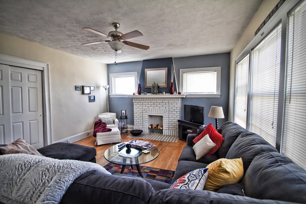a living room with a ceiling fan and a fireplace