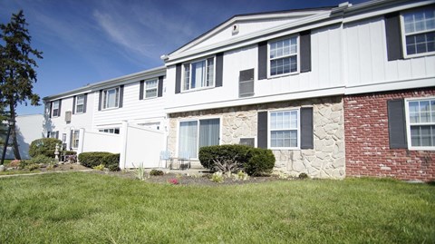 a white house with black shutters and a lawn