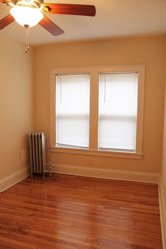 a room with a radiator and two windows