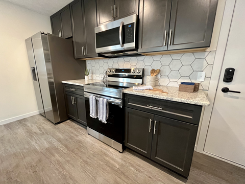 a kitchen with stainless steel appliances and black cabinets