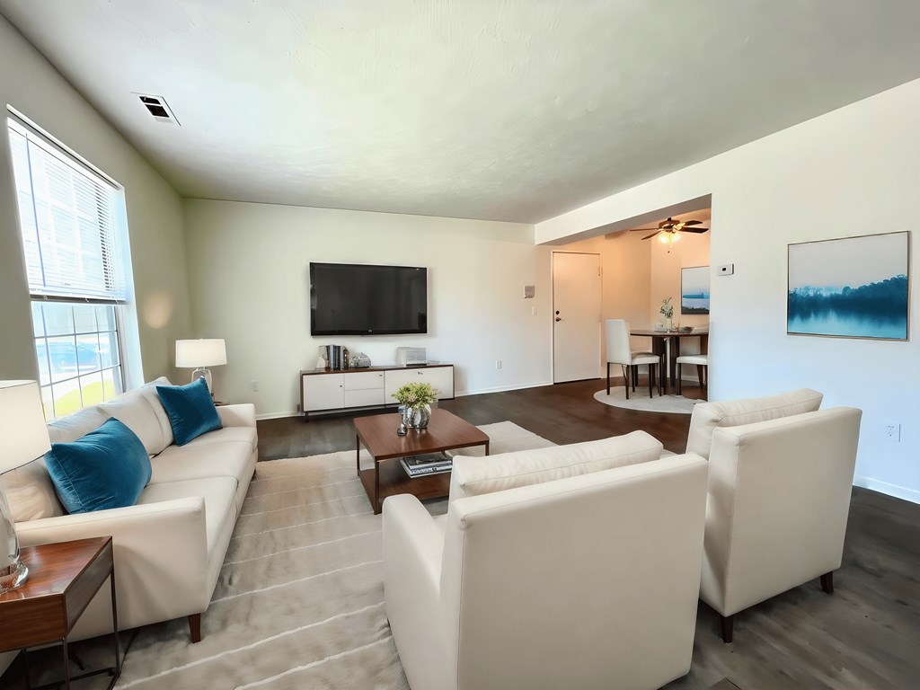 a living room with white couches and chairs and a television at Renova of Brunswick, Ohio 