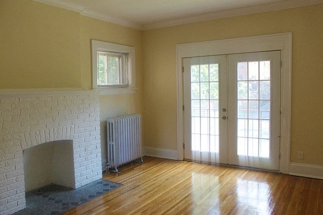a living room with a white brick fireplace and a door