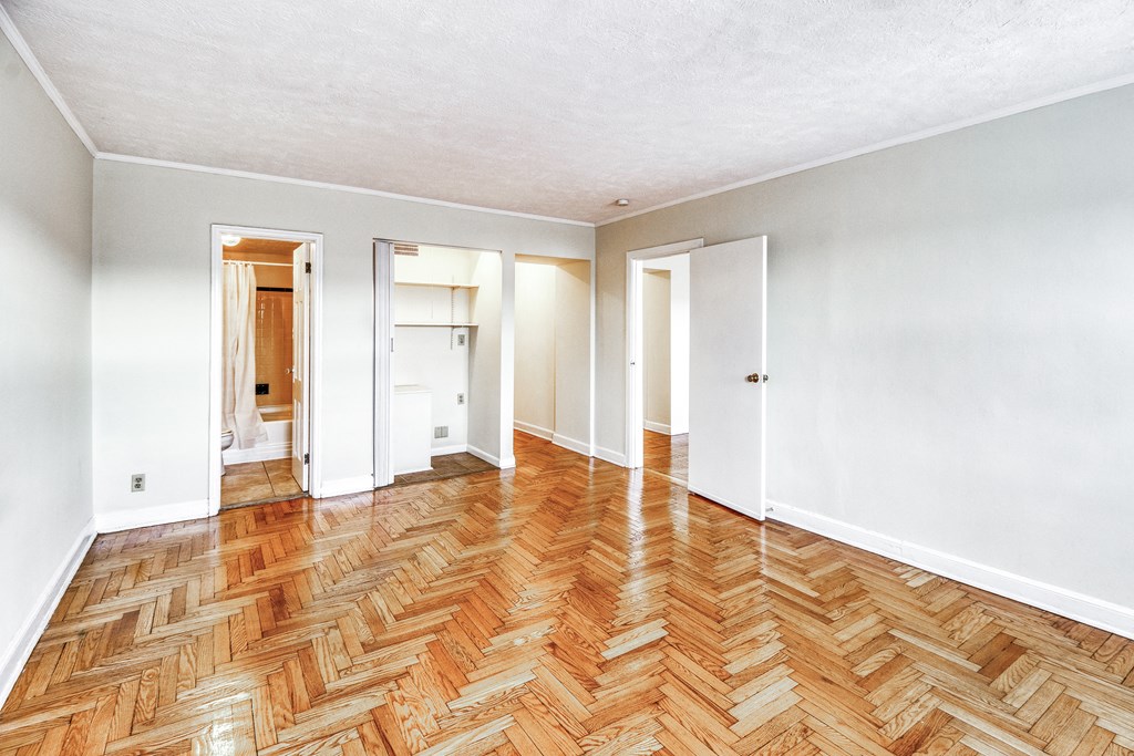 a renovated living room with wood flooring and white walls