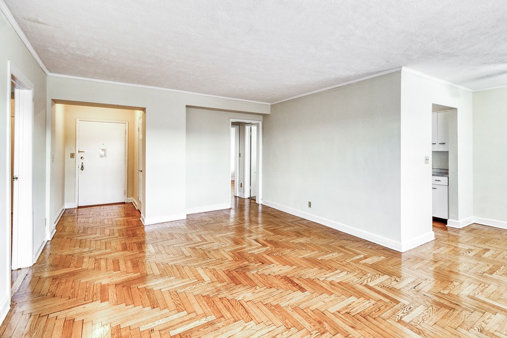 an empty living room with wood flooring and white walls