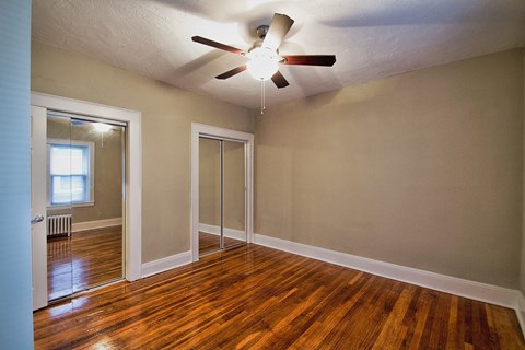 the living room of an empty house with a ceiling fan