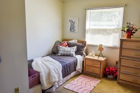 a bedroom with a bed and a dresser and a window