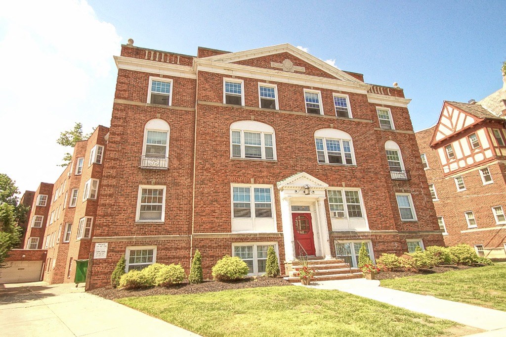 the front of a brick building with a red door