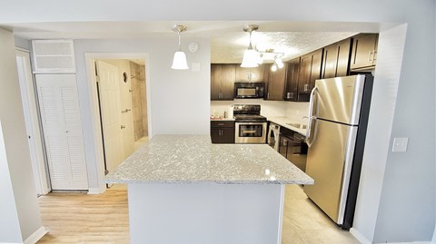 a kitchen with a island and a stainless steel refrigerator