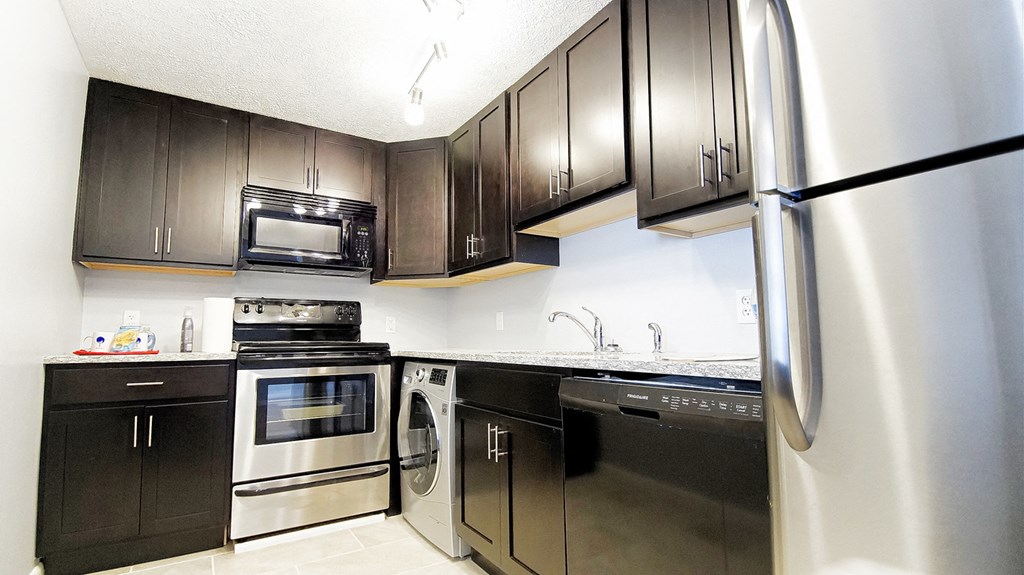 a kitchen with stainless steel appliances and black and white cabinets