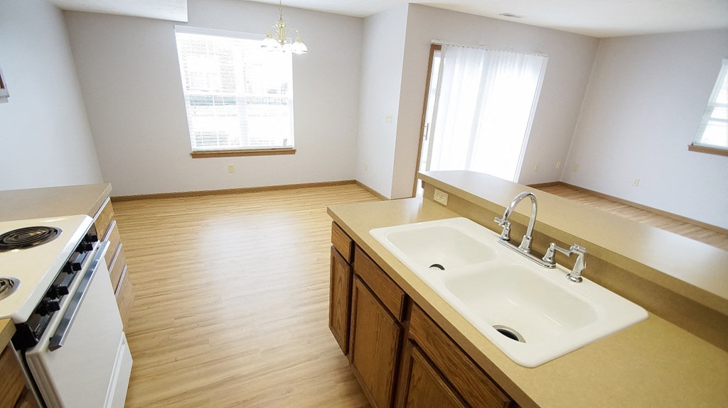 an empty kitchen with a sink and a stove and a window