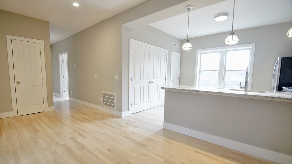 an open kitchen and living room with a hard wood floor