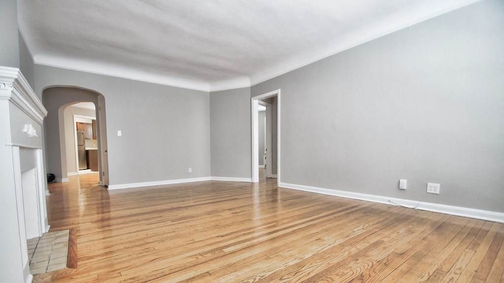 the living room and dining room of an empty house with wood floors