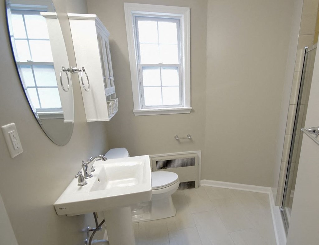 a bathroom with a sink toilet and a mirror
