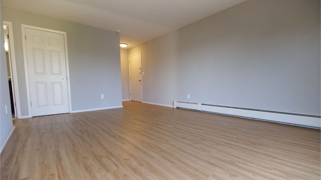 the living room and dining room of an empty house with wood floors
