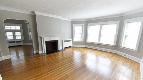 an empty living room with wood floors and a fireplace