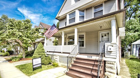 the front of a house with an flag on the porch