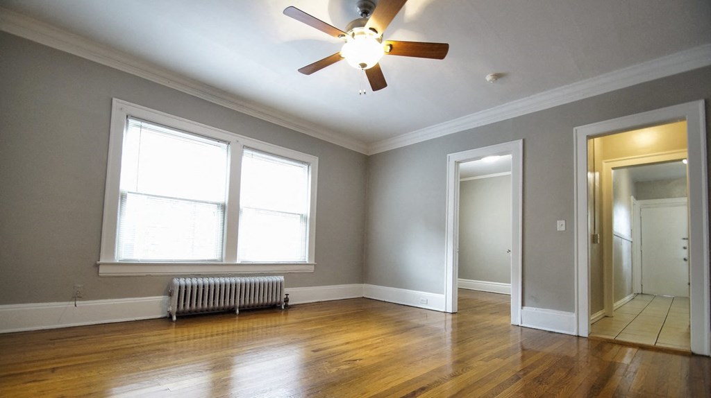 the living room of an empty house with a ceiling fan