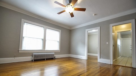the living room of an empty house with a ceiling fan